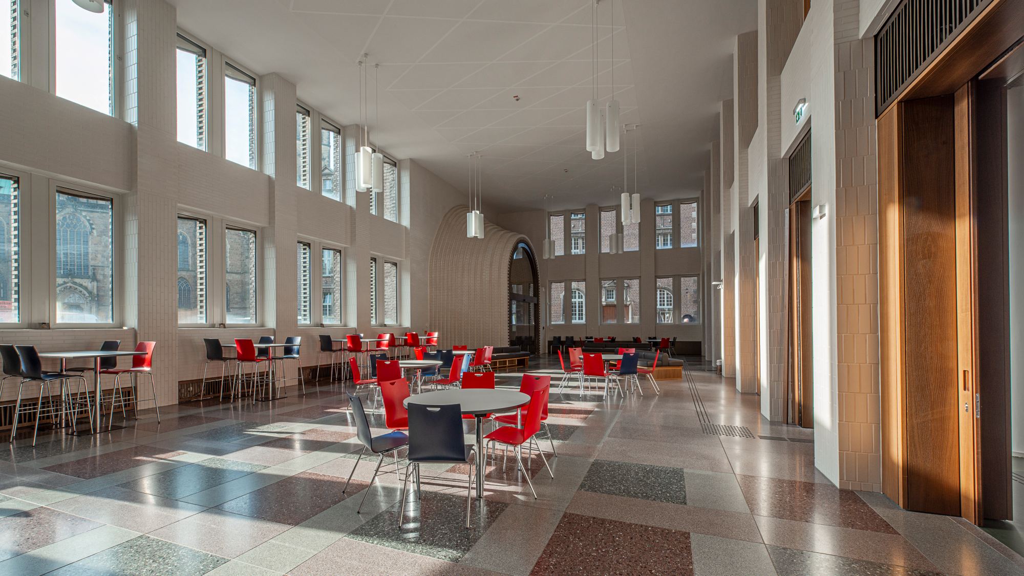 : Blick in die Kassenhalle mit mehreren Tischen und Stühlen.