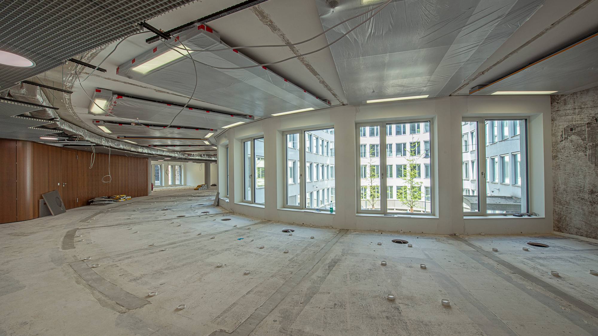 Ein Blick in den leeren Raum, der zur Bibliothek umgebaut wird. Im Boden sind Verankerungen zu sehen.