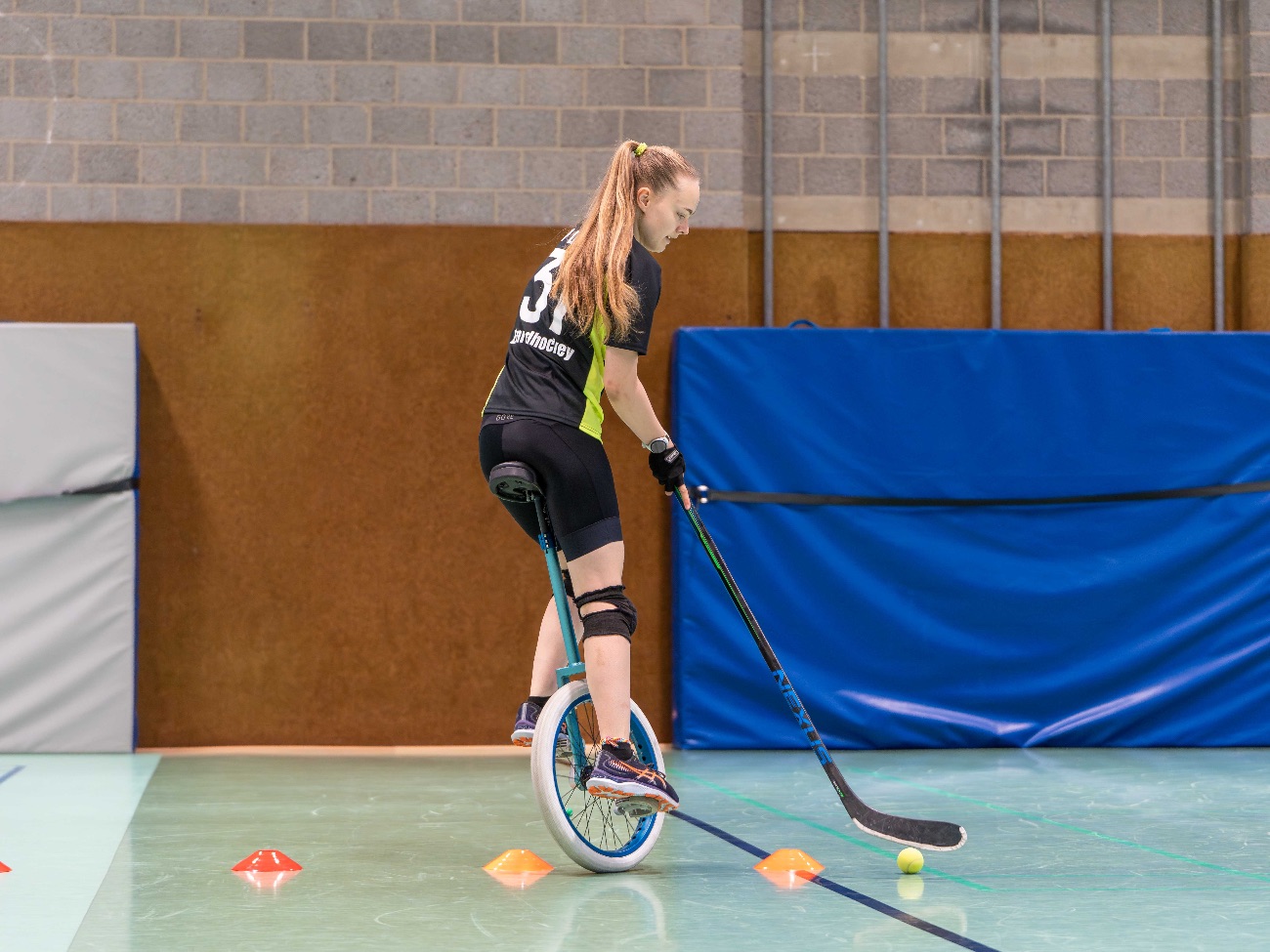 Maya Hartmann rides her unicycle around cones.