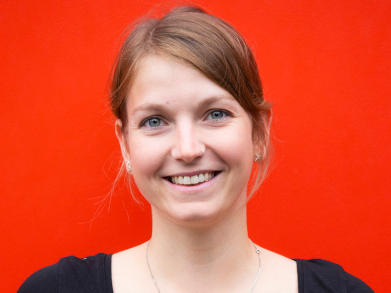 Jasmin in front of a red background.