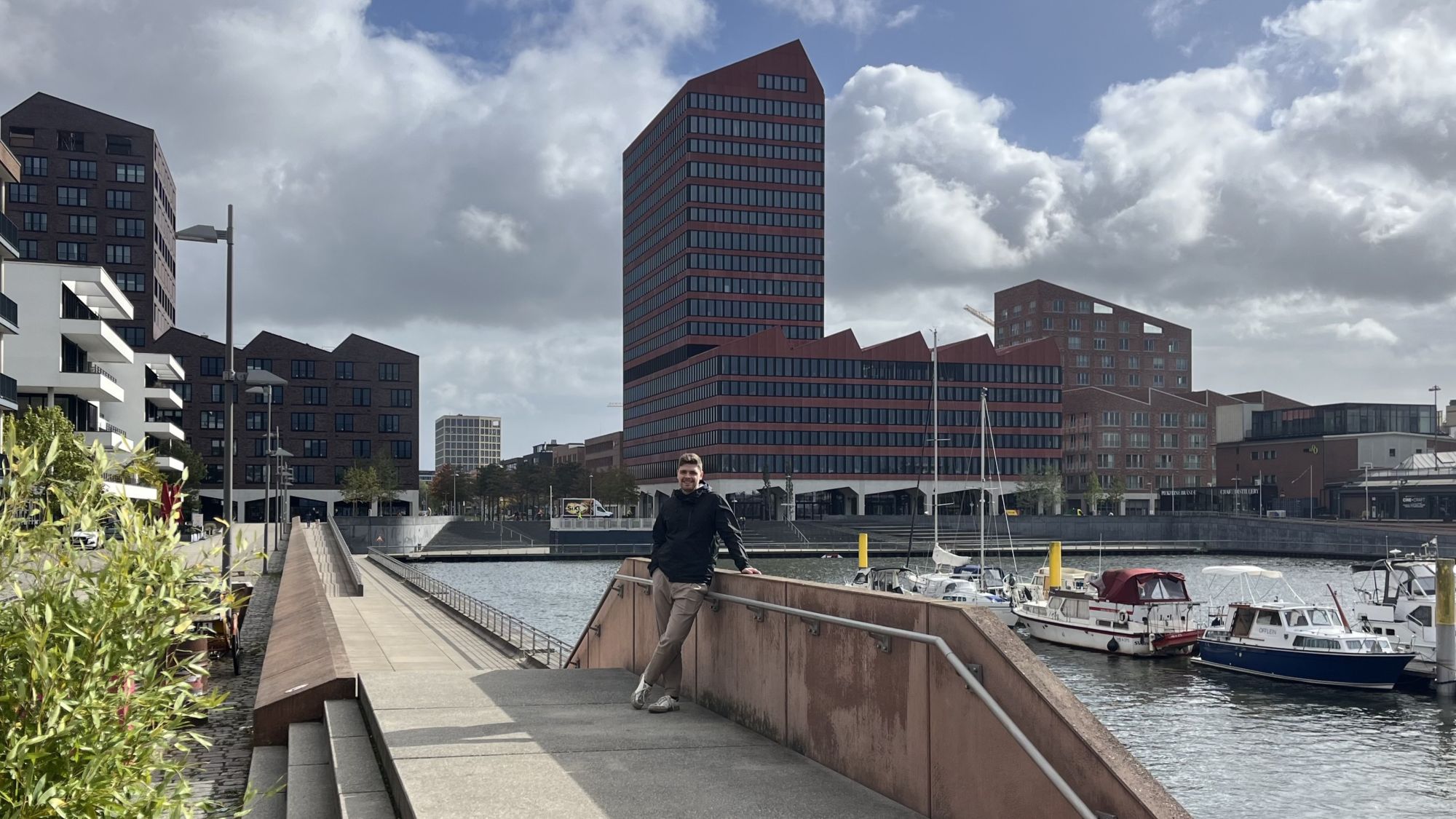 Student Marius is standing next to the harbor basin in Bremen’s Überseestadt.