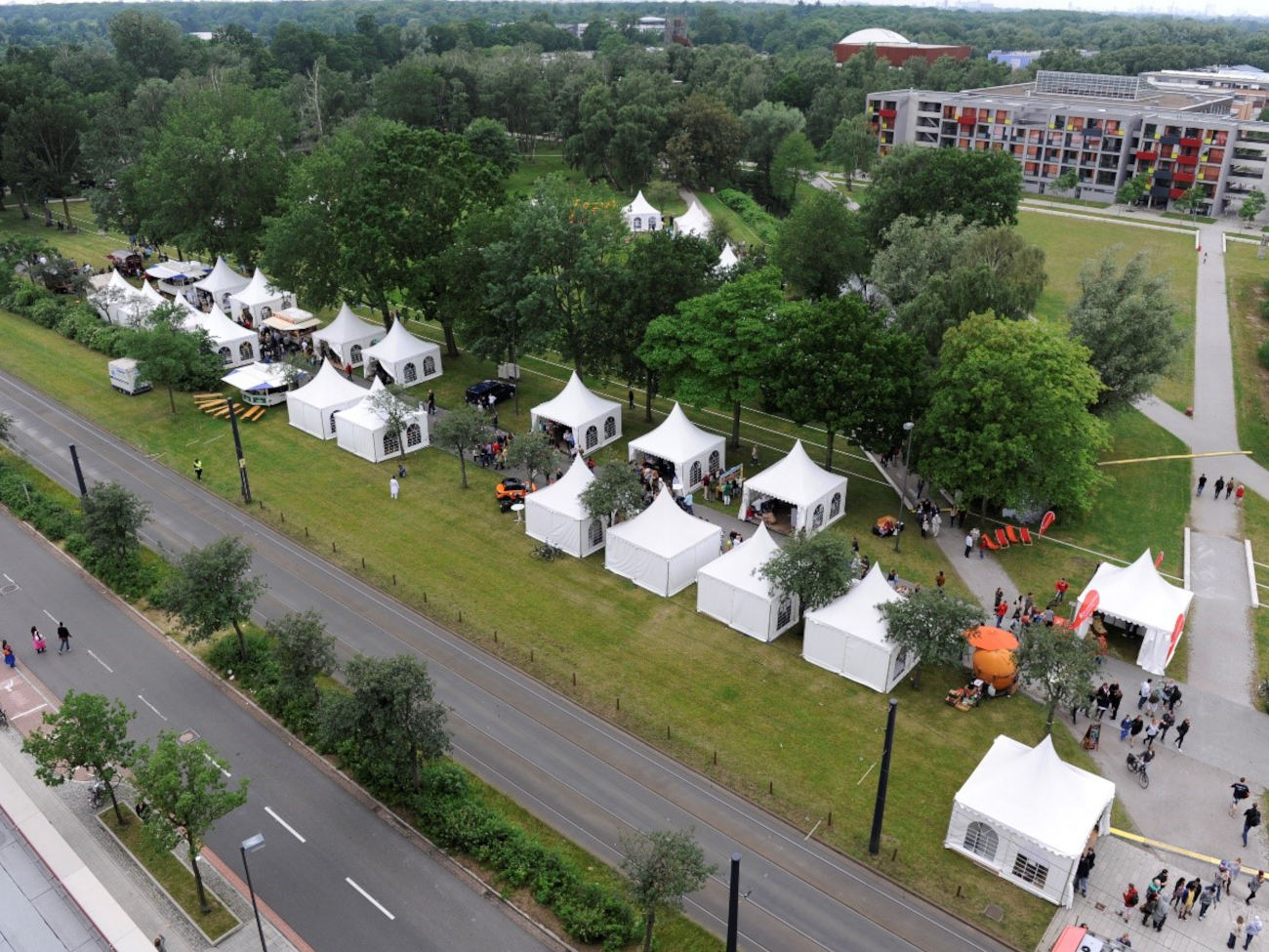 A few white pagoda tents stand on the lawns next to the streetcar tracks on Library Street.