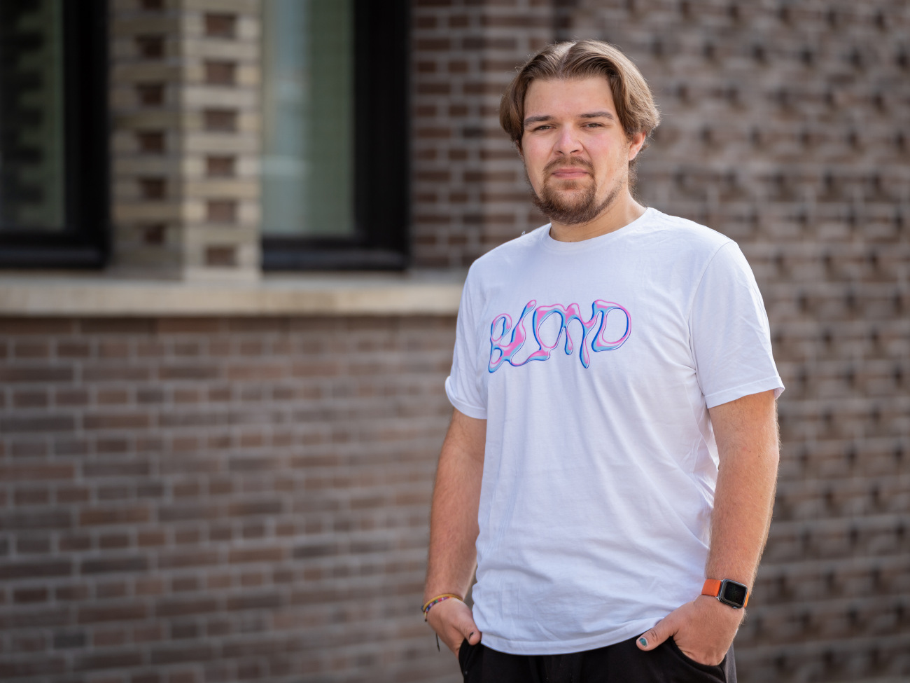 Ein junger Mann steht vor dem Gebäude des Uniforums am Domshof.
