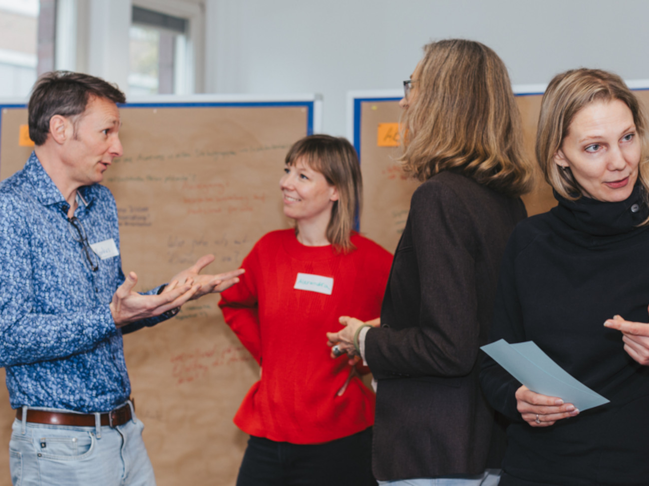 Four people can be seen talking to each other.