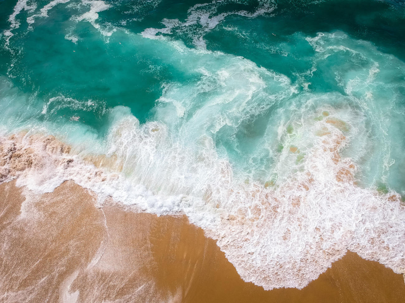 Türkises Meerwasser trifft auf das sandige Ufer