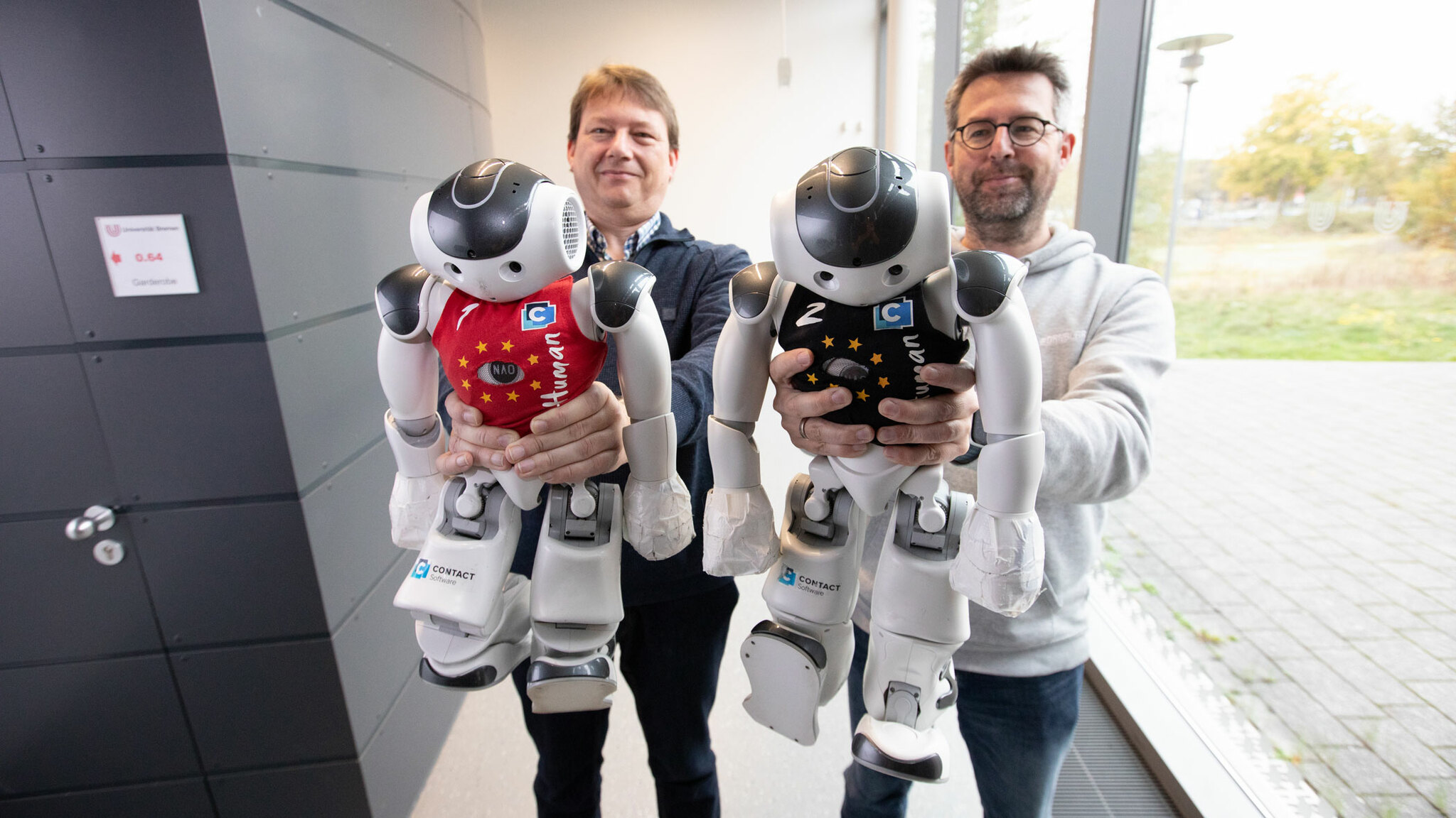 Dr. Thomas Röfer und Dr. Tim Laue halten die Roboter-Kicker in den Händen