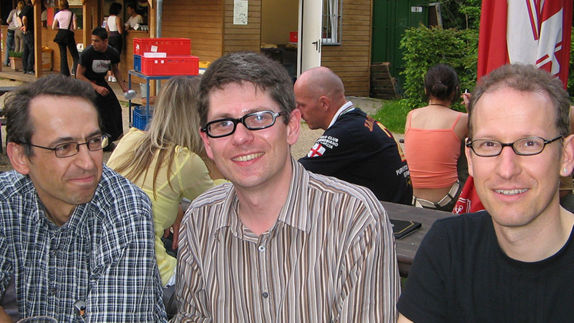 Three men are sitting next to each other at a table.