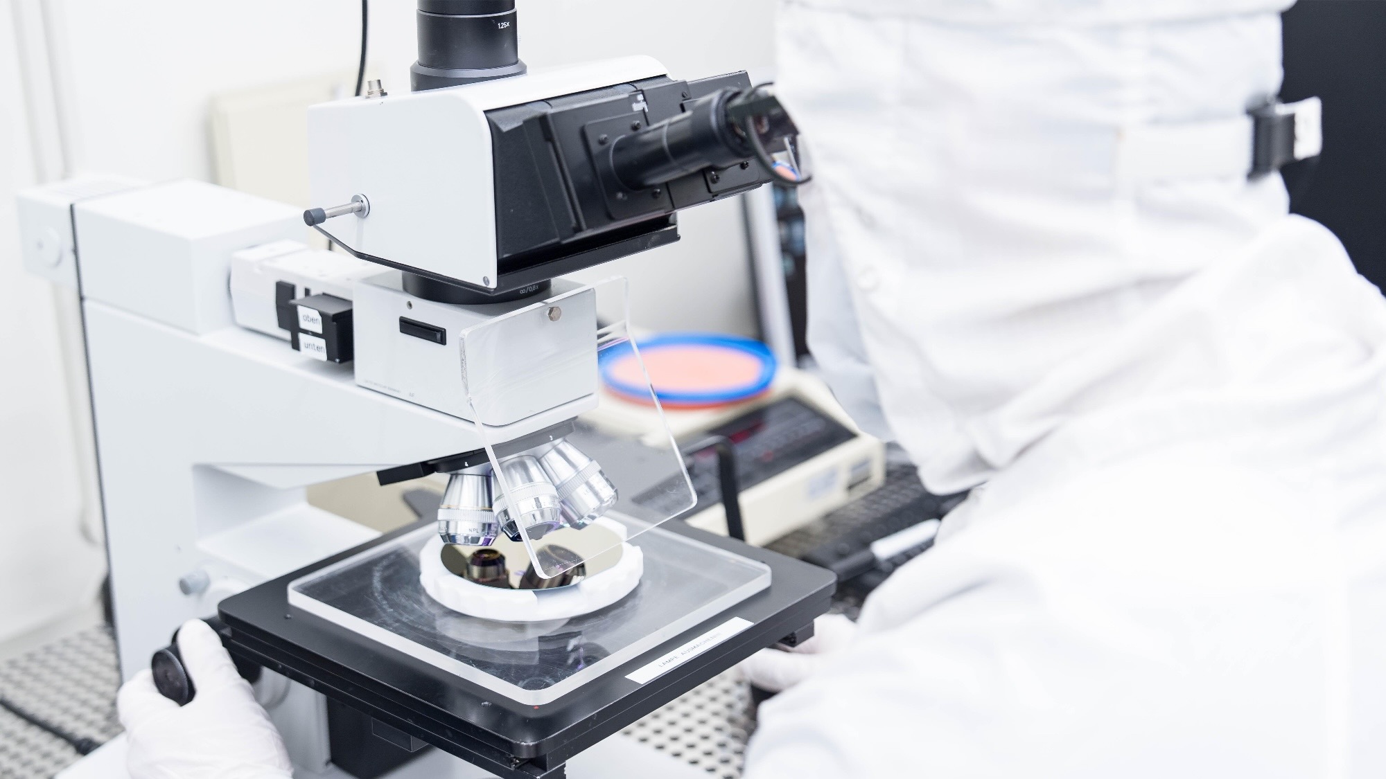 Picture of a person looking into a microscope. 