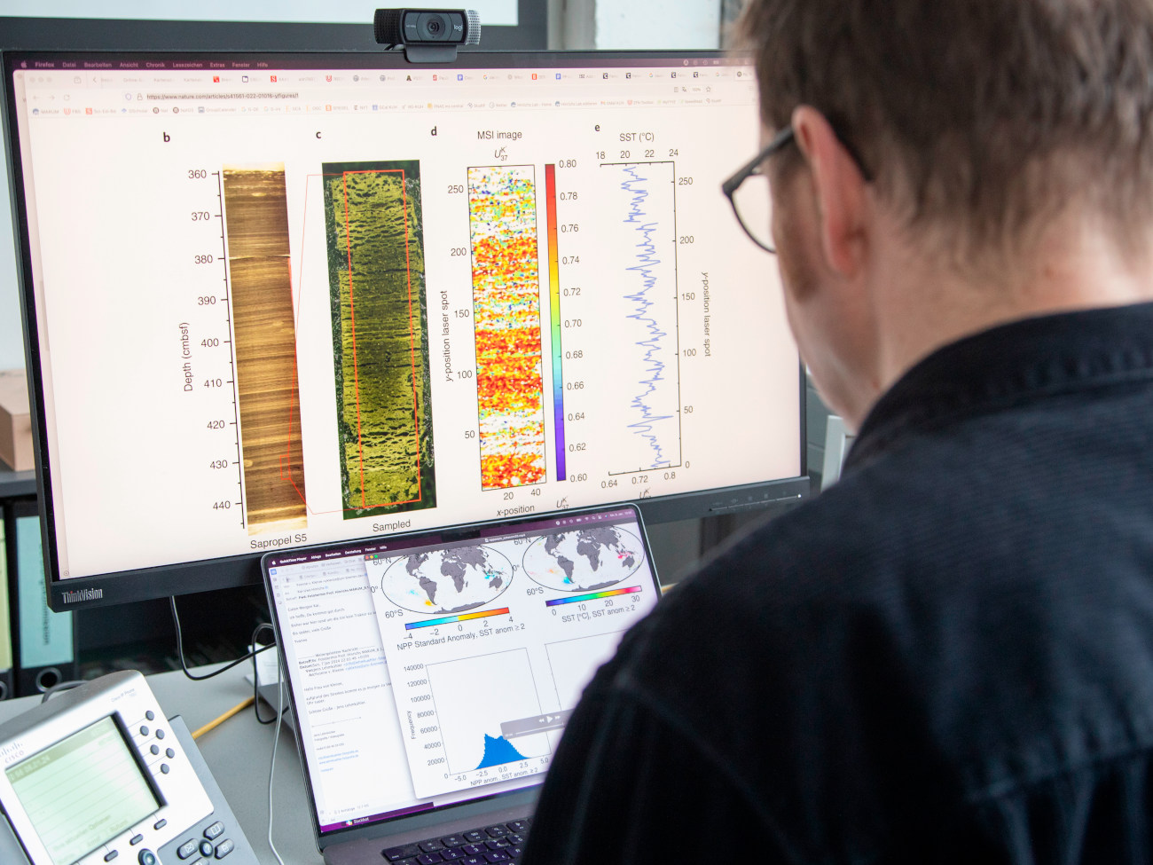 Kai-Uwe Hinrichs sitzt vor einem Computerbildschirm, auf dem die Verteilung von Molekülen in einem Ausschnitt eines Sedimentkerns zu sehen ist.