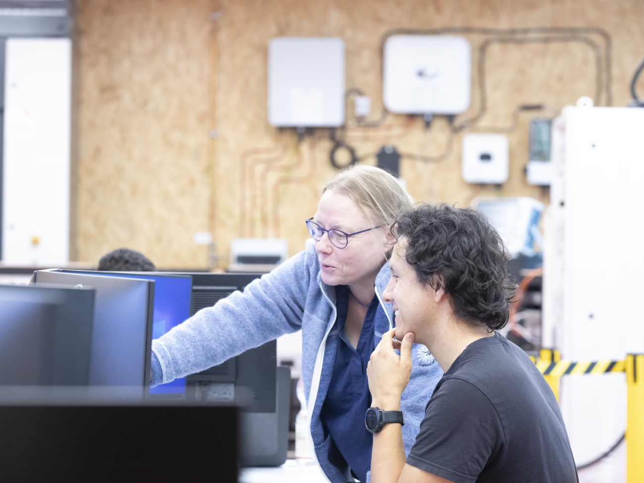 Die Professorin zeigt ihrem Kollegen etwas auf dem PC.