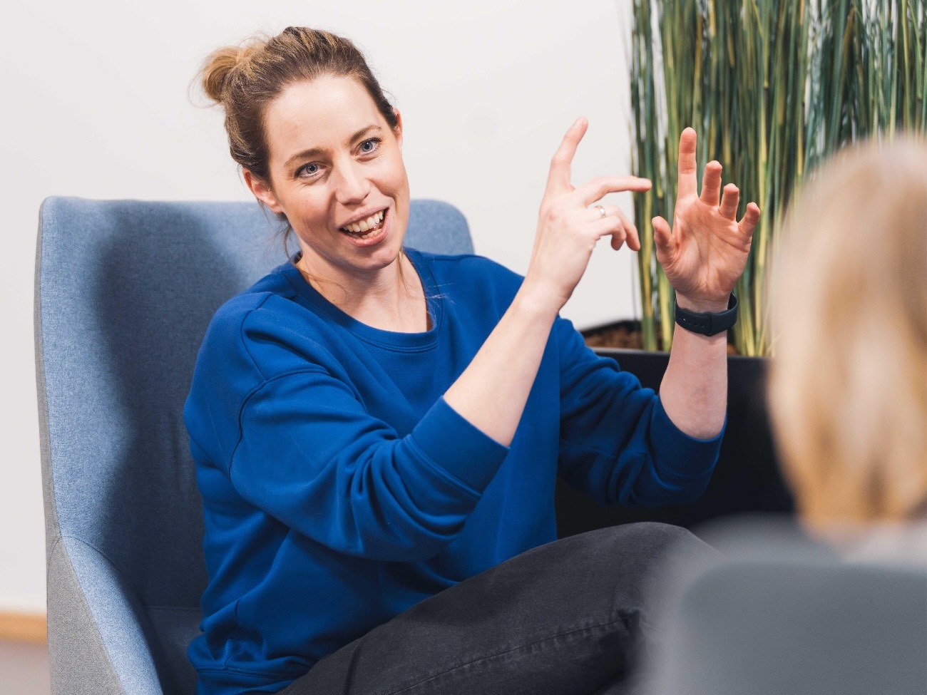 Charlotte Kleint sitzt vor einer Person und gestikuliert etwas.