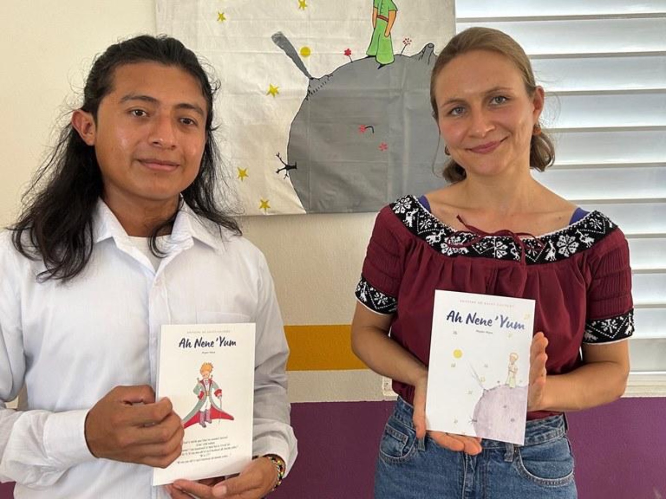 Stanley Peck and Nicole Hober each hold a Mopan language copy of the book The Little Prince.