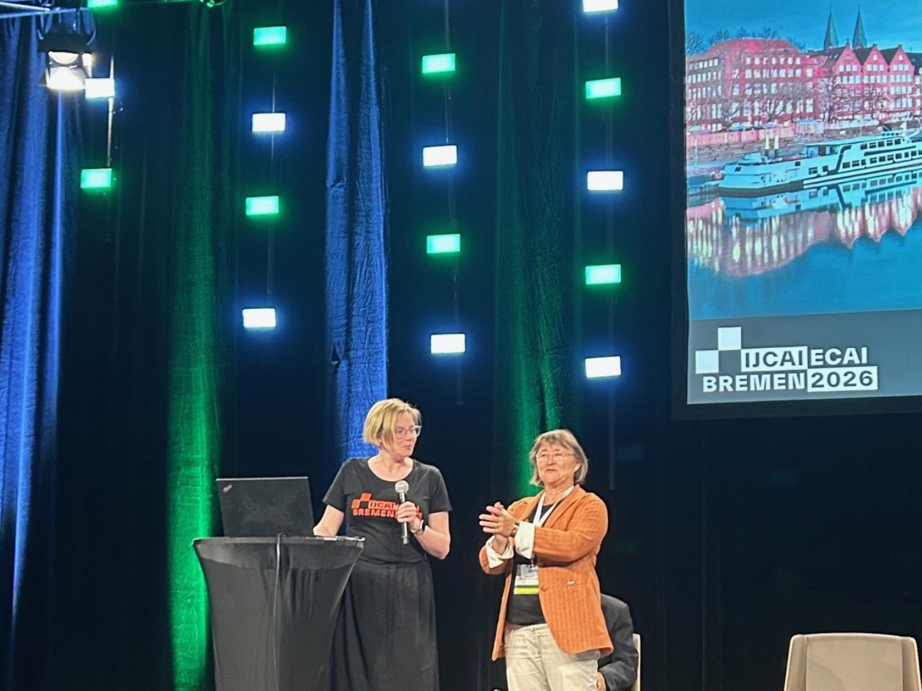 Prof. Dr. Schultz, and Dr. Monika Michaelis on stage at 2025 IJCAI in Montreal, Canada.