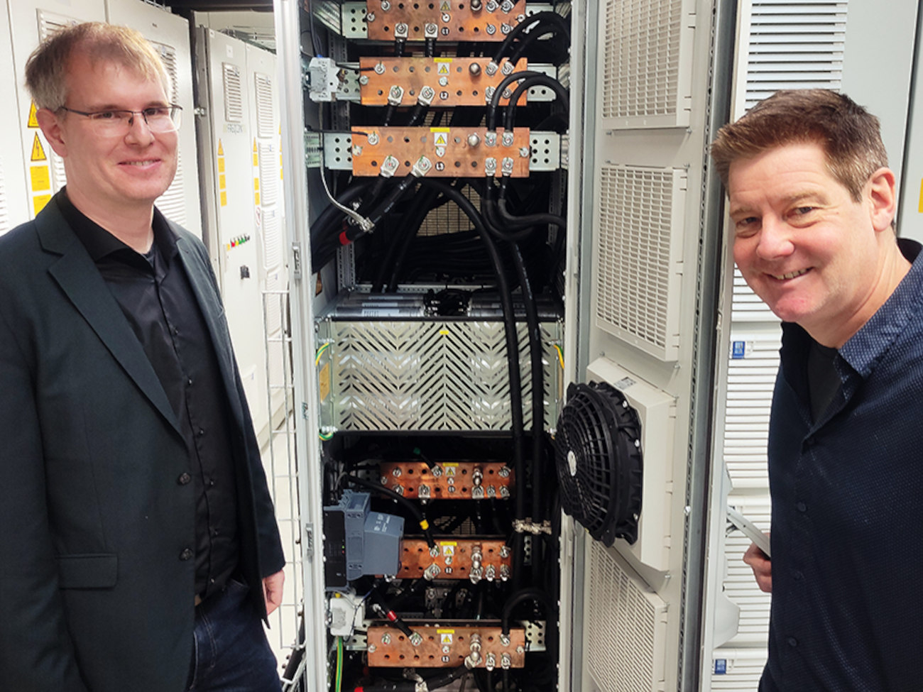 Wilfried Holzke und Holger Raffel präsentieren den Schaltschrank eines Frequenzumrichters