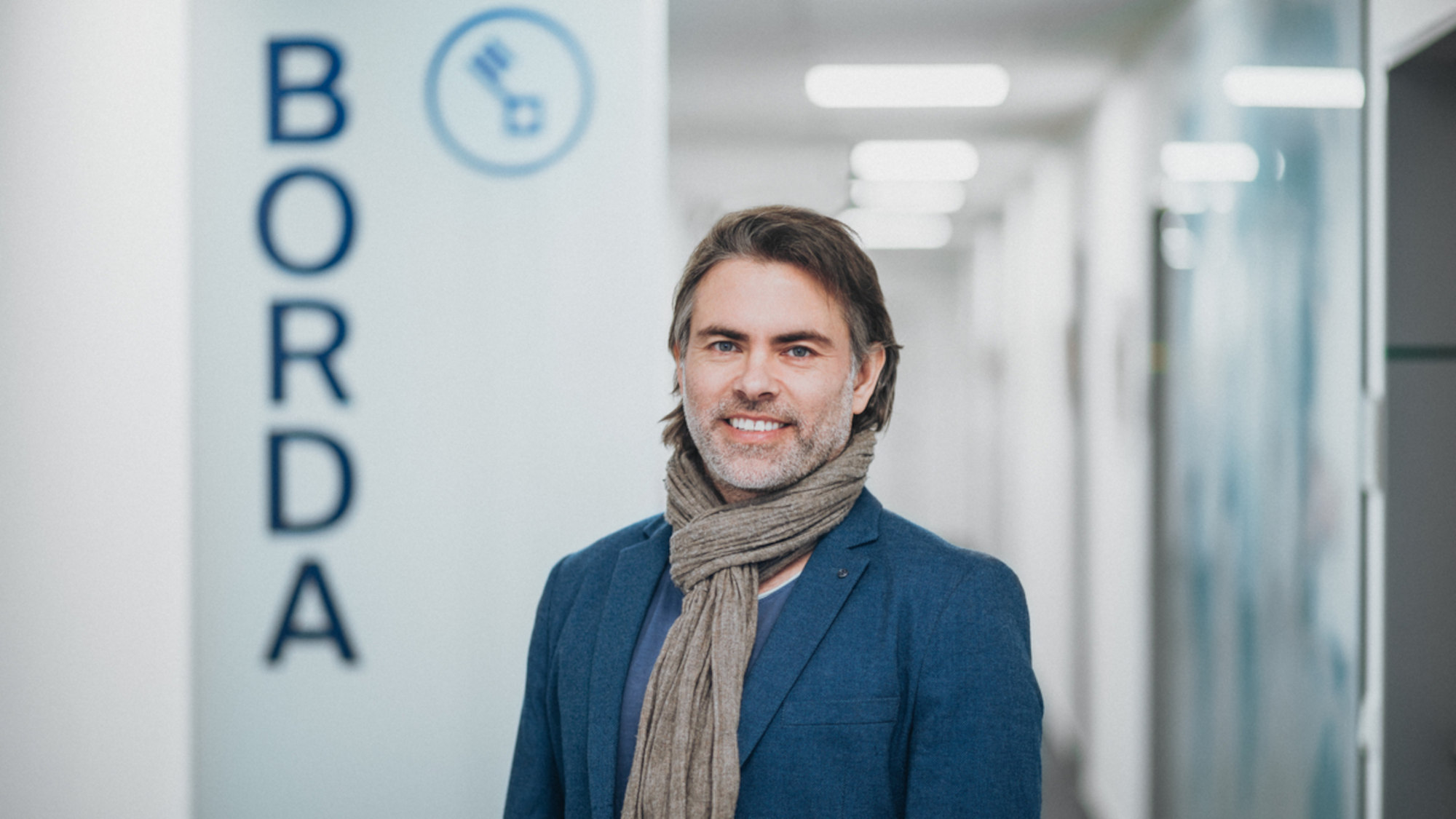 Alexander Wolf is standing in a hallway, behind him you can see the lettering BORDA.