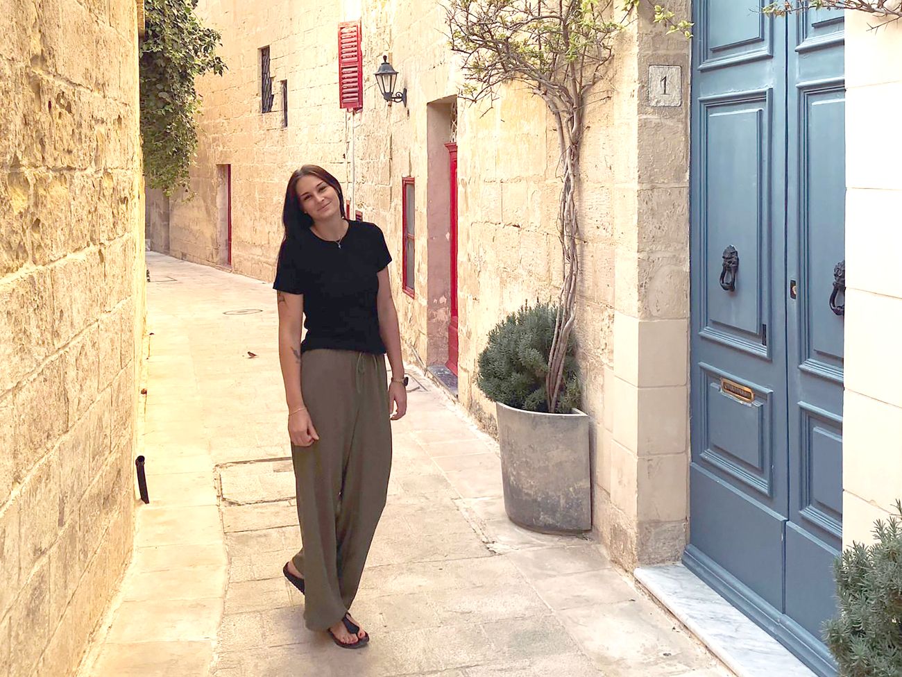 Eine Frau steht in einem Altstadtgebiet auf Malta.
