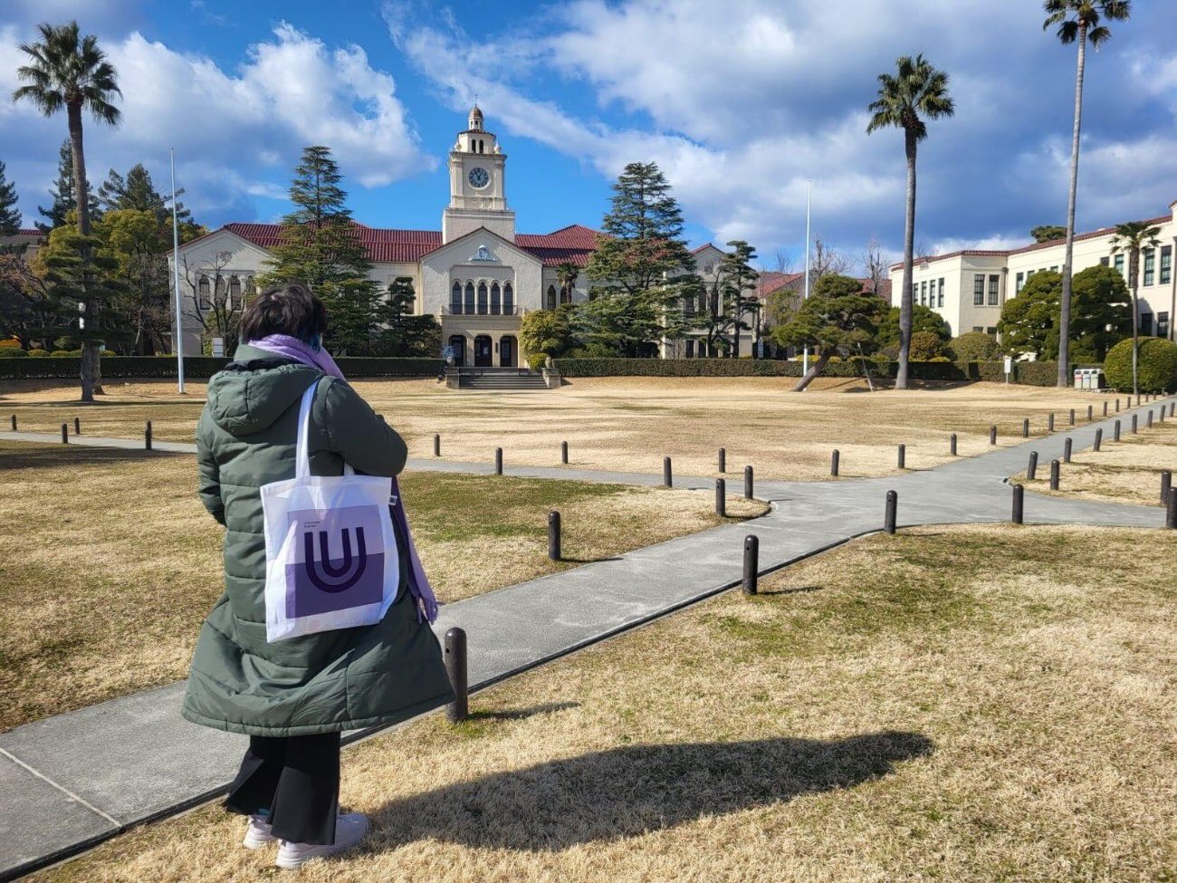 Bild von Jasmin, wie sie im Park vor dem Uhrturm der Partneruniversität in Japan steht.