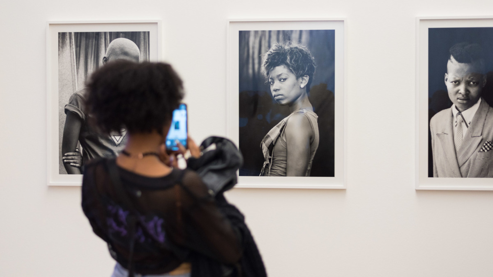 Zu sehen ist eine Frau, die ein Kunstwerk bei der Ausstellung „Generation*. Jugend trotz(t) Krise“ anschaut.