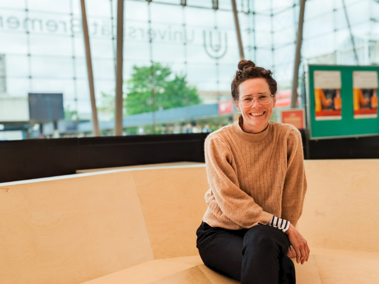 Artist Sarah Lüdemann is pictured sitting on the artwork 