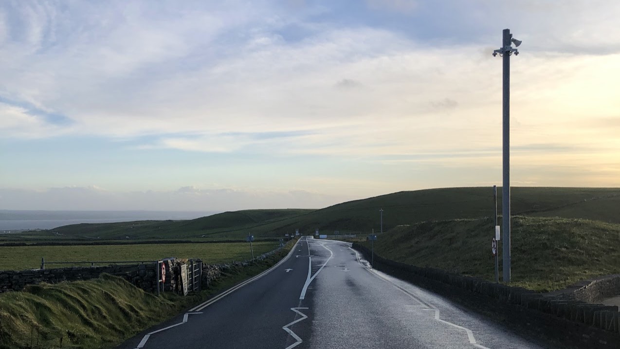 Eine Straße an dessen Ende Berge zu sehen sind