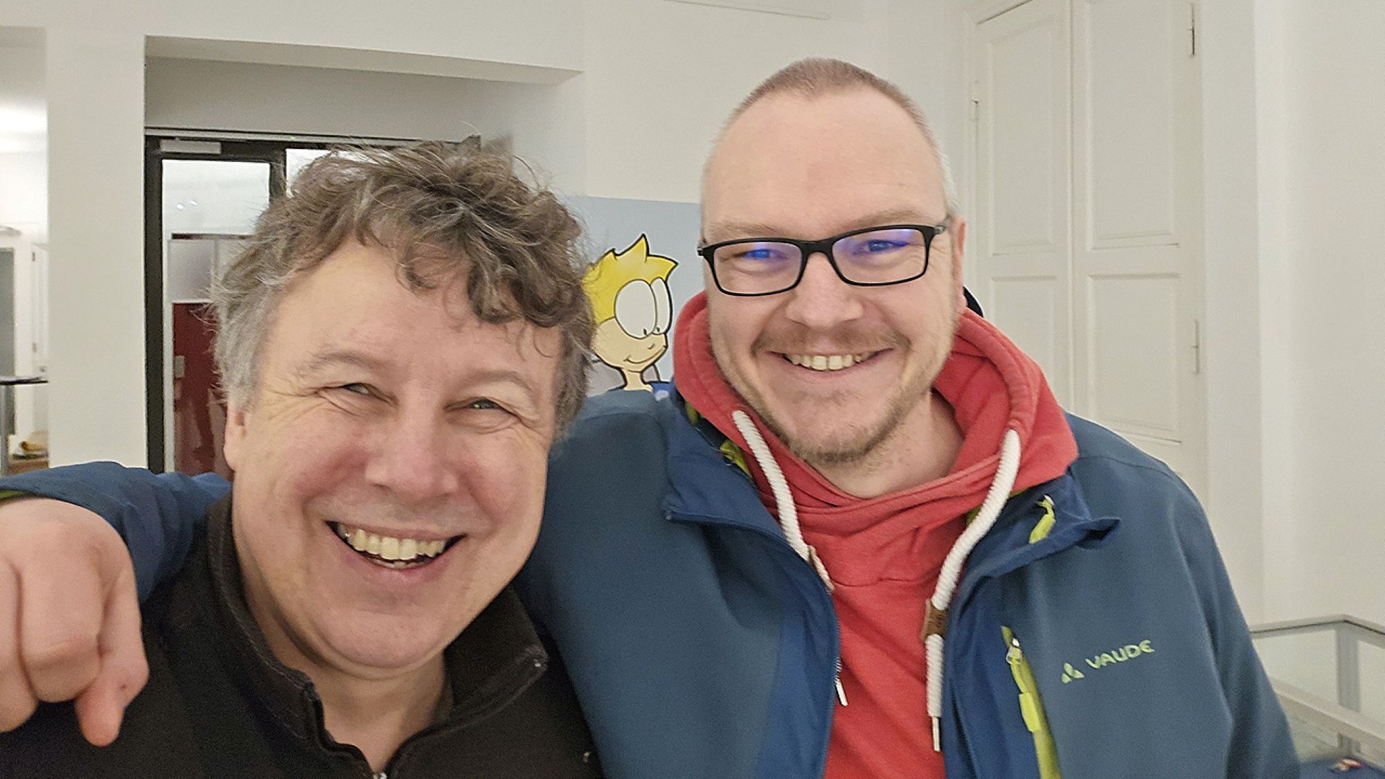 Ein Selfie von zwei Herren, die in die Kamera lächeln.