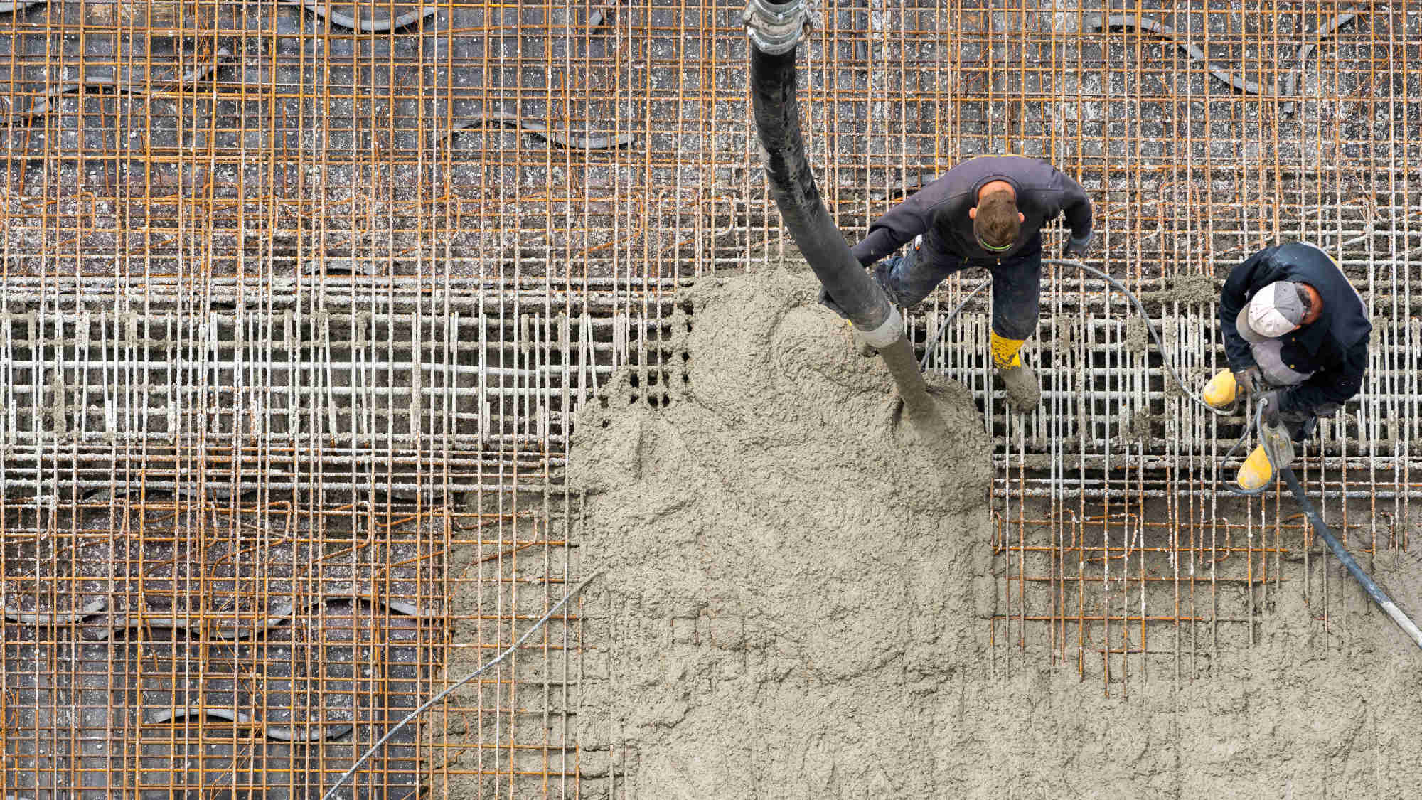 A bird's eye view of two men pouring cement