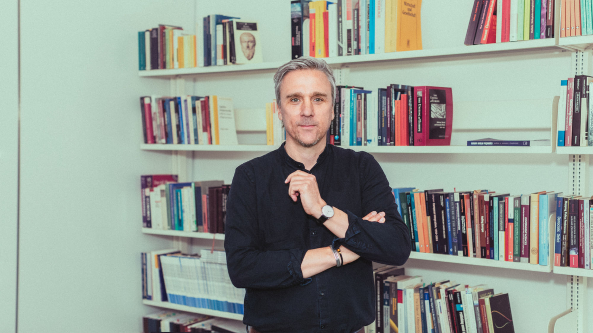 Arndt Wonka standing in front of a bookshelf