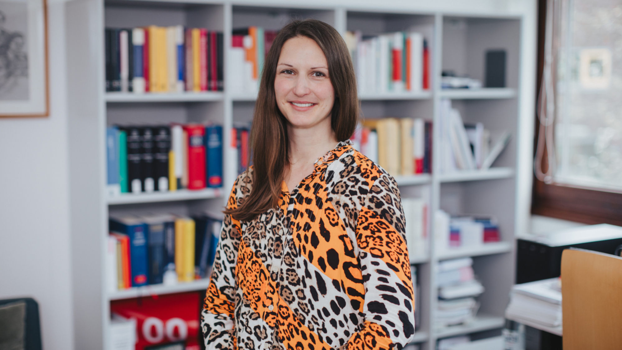 Pia Lange standing in front of a bookshelf