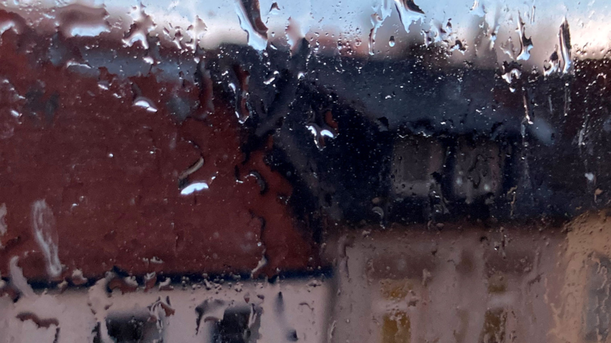 Rain on the window and blurred houses in the background