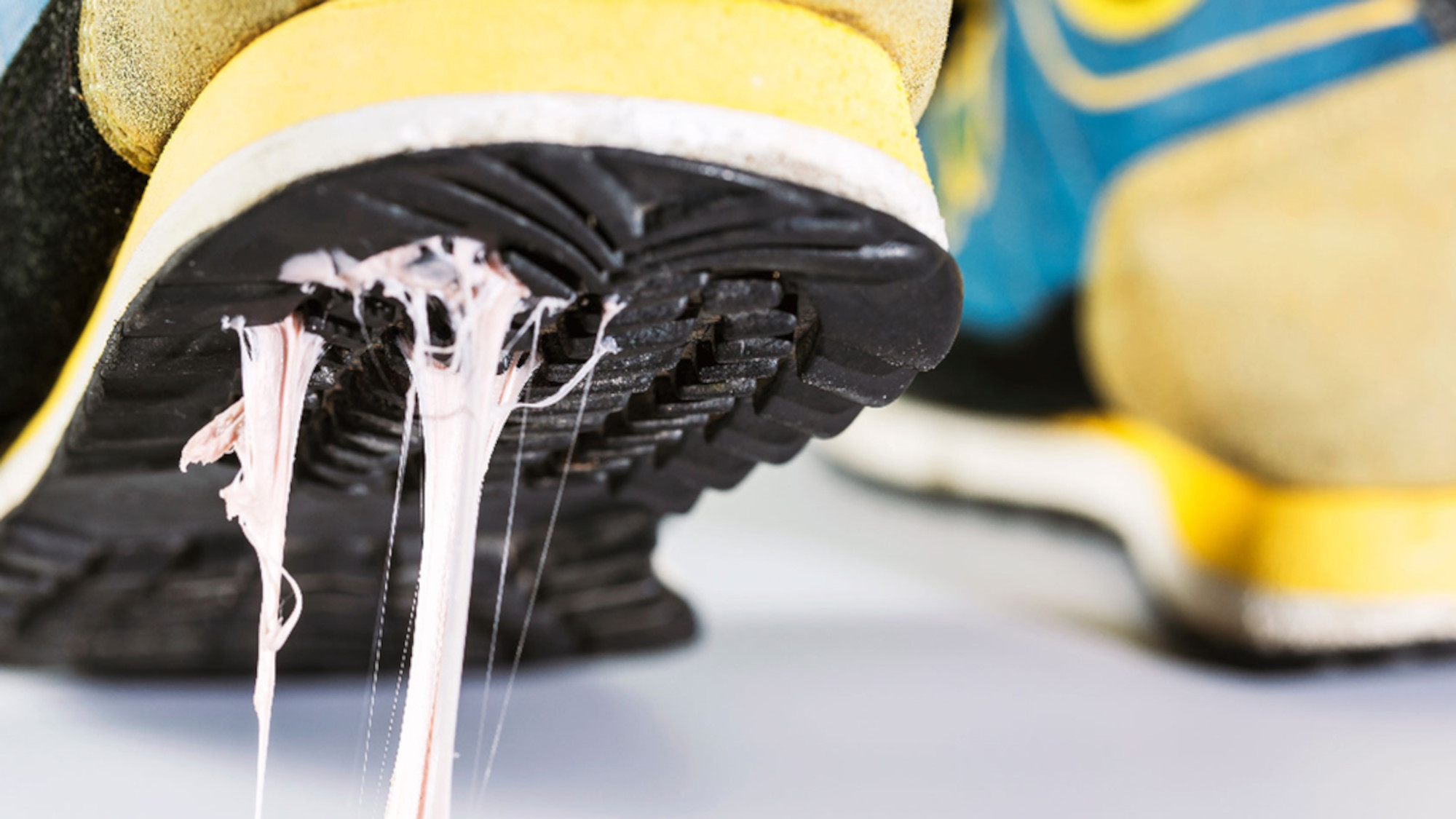 A piece of chewing gum sticks to the sole of a sneaker